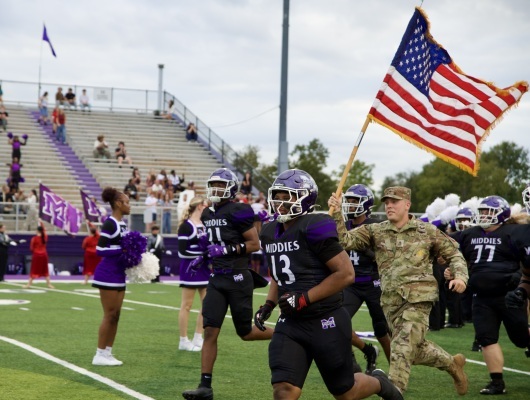 army staff running a flag with football team